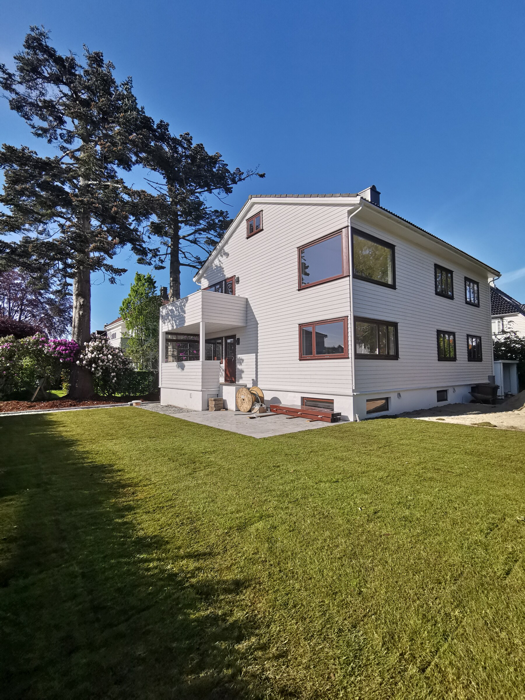 Ferdig plen med granittkant langs det hvite huset i solskinn