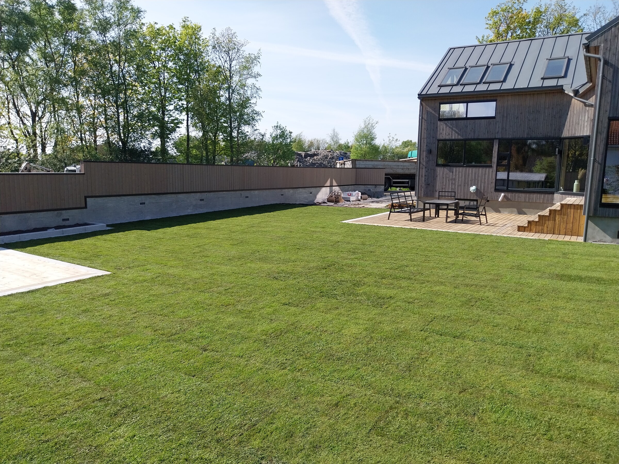 Panoramabilde av den ferdige hagen med plen, terrasse og støttemurer
