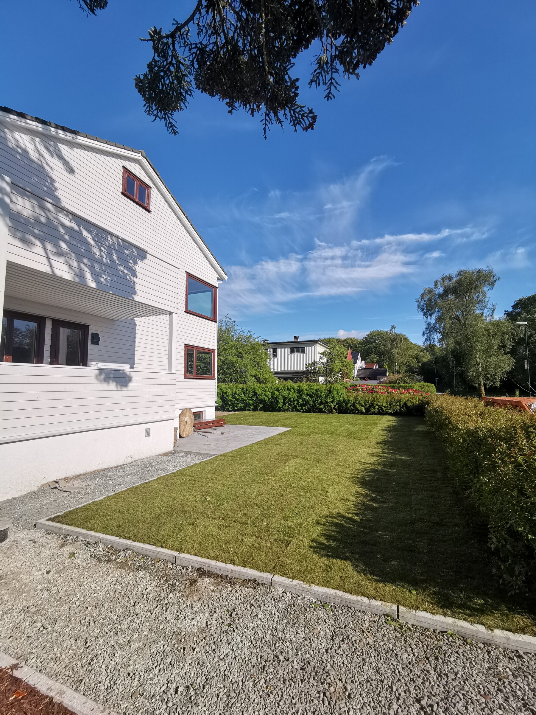 Ny ferdigplen avgrenset av granittkant og en grusstripe langs huset