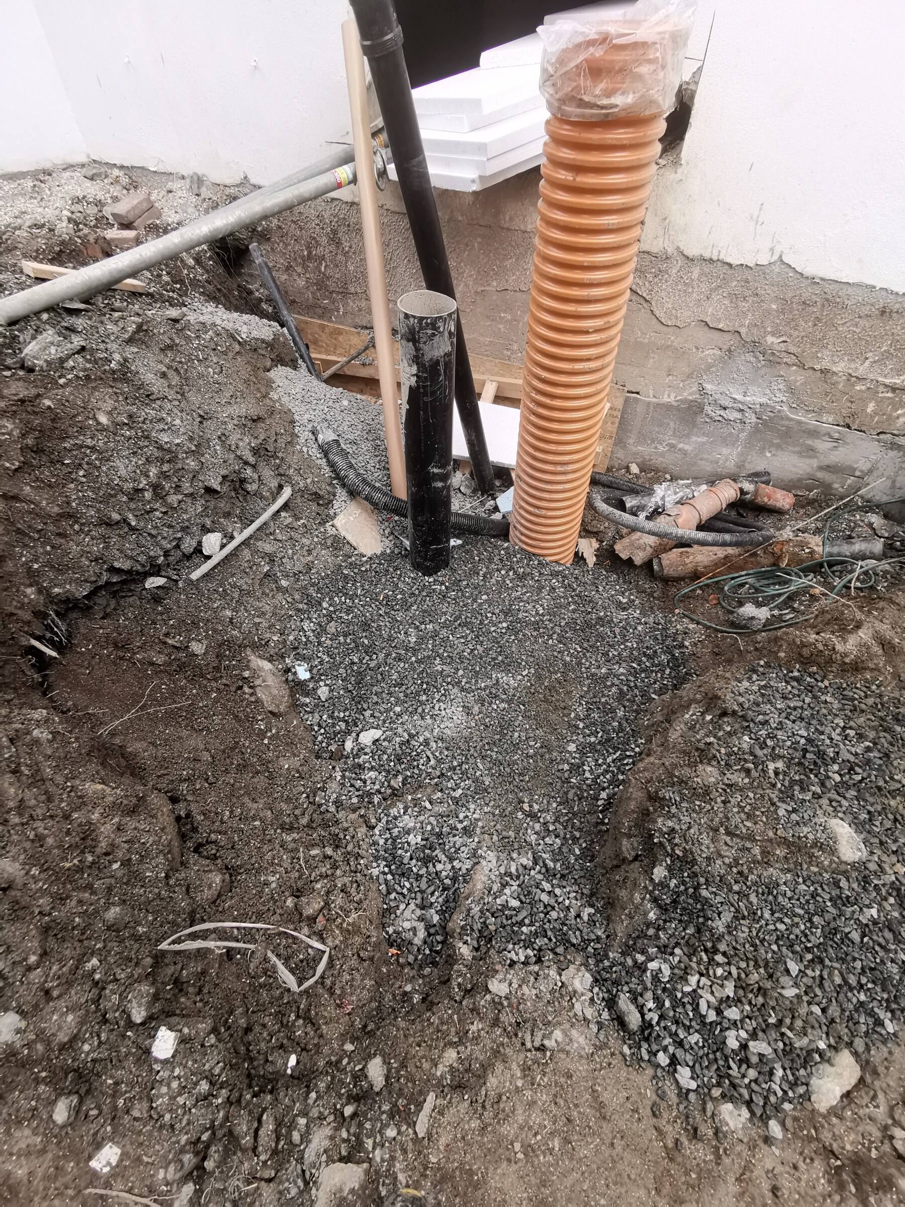 Detalj av drensrør og masser ved grunnmuren