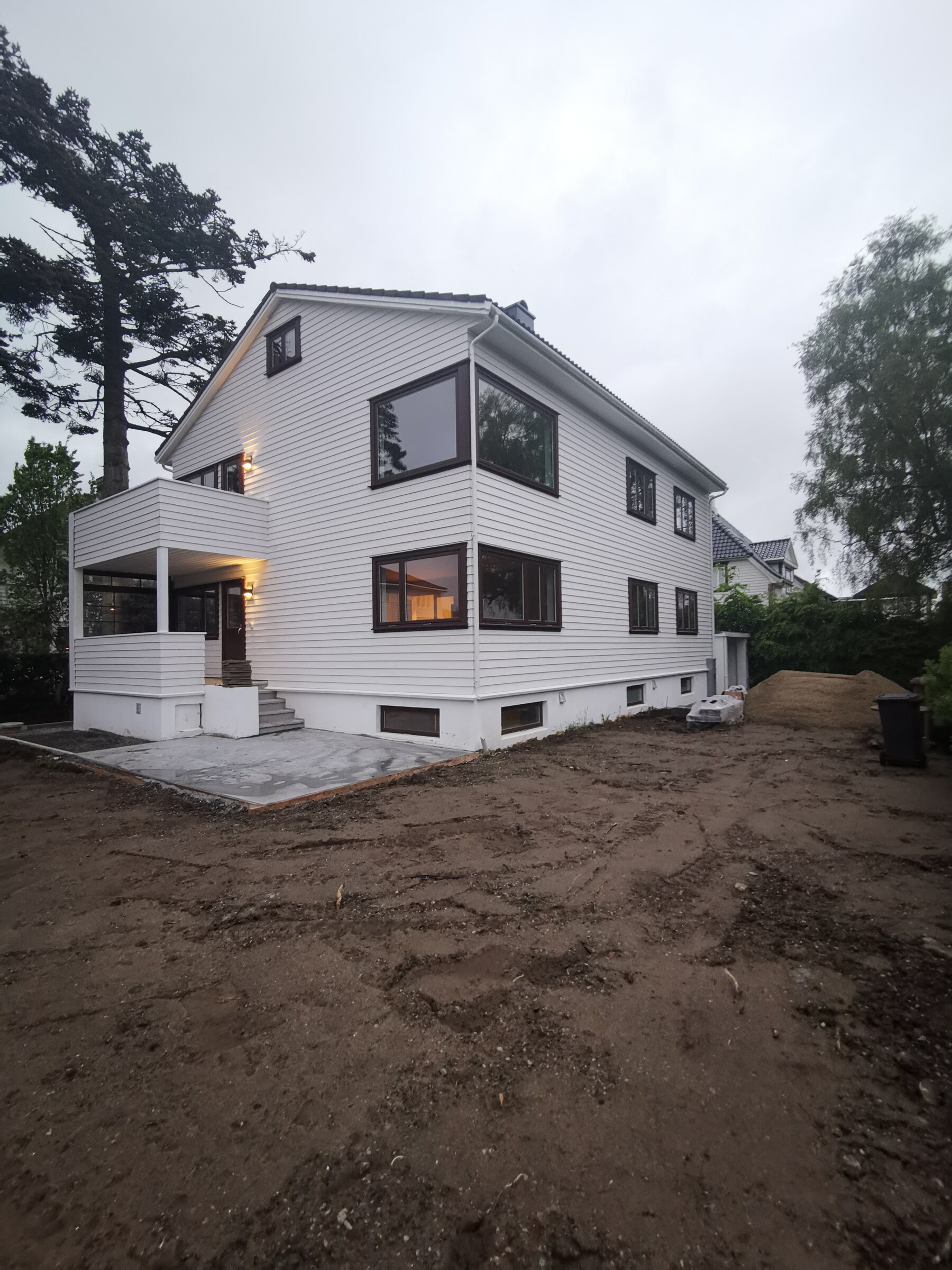 Bar grunn og nystøpte betongflater rundt huset