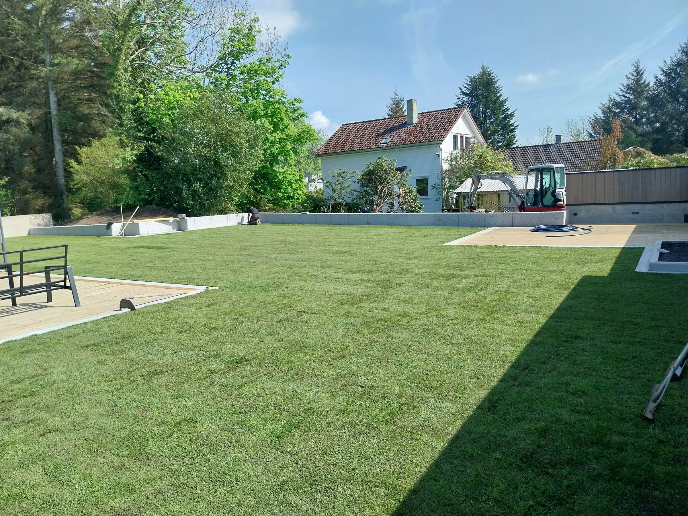 Terrassebord i tre foran plenen med kabelrør klargjort på dekket