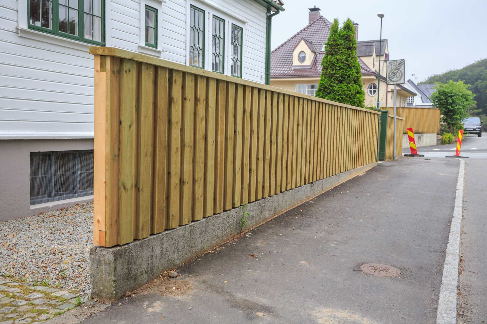 Eiendomsgrense med mur, gjerde og etablert plen