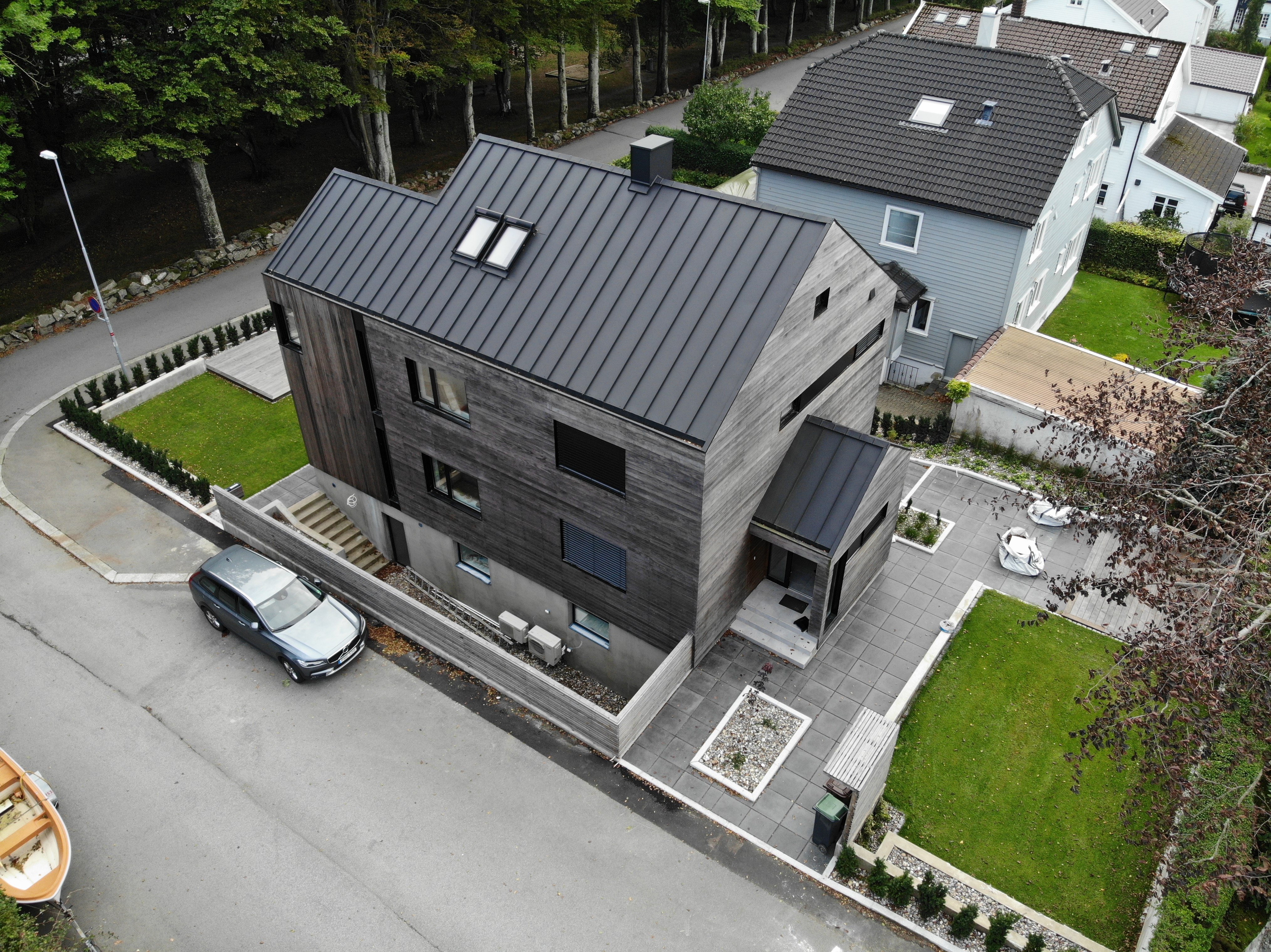 Carport i aluminium med glasstak ved den ferdige innkjørselen