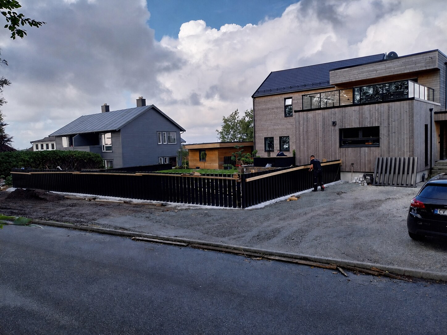 Gjerde i aluminiumsprofiler under montering rundt hagen