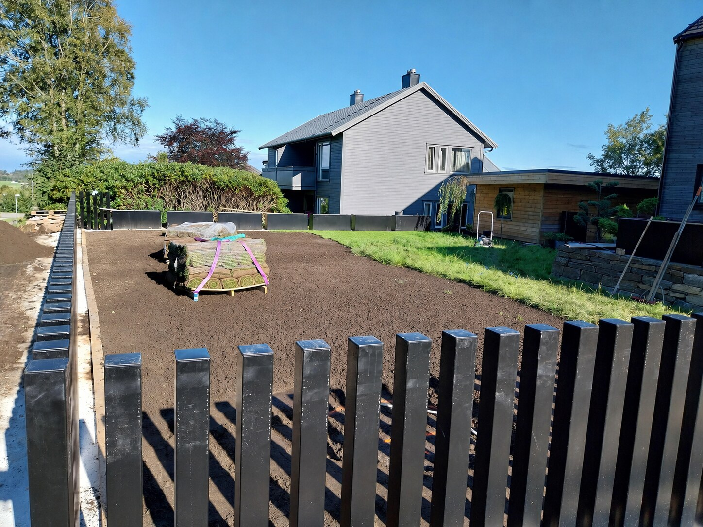 Klargjort mørk matjord og ruller med ferdigplen klare til legging