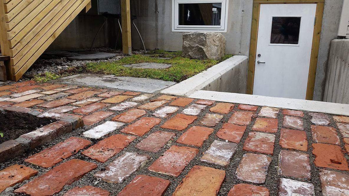 Detalj av teglflate med grønt tak i bakgrunnen