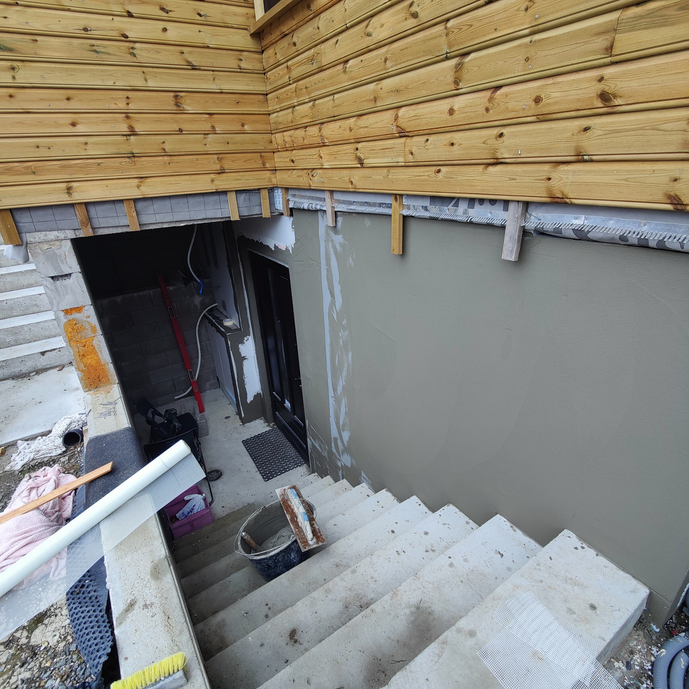 Betongtrapp som går ned til den ferdige kjellerinngangen