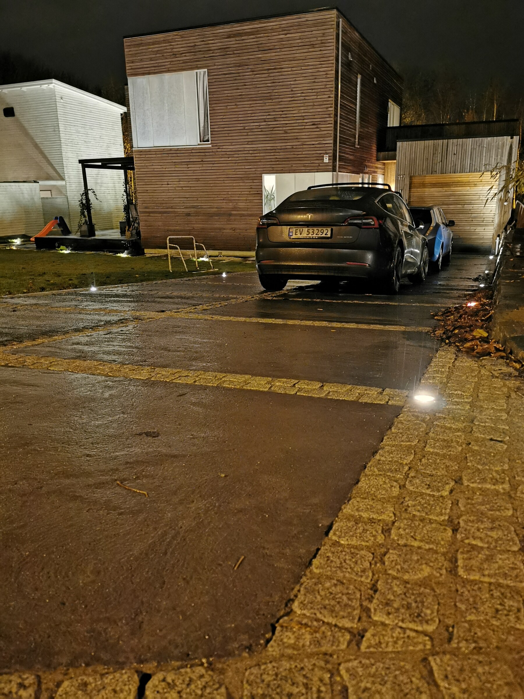 Våt betongoverflate om kvelden der integrert LED-belysning markerer granittfeltene