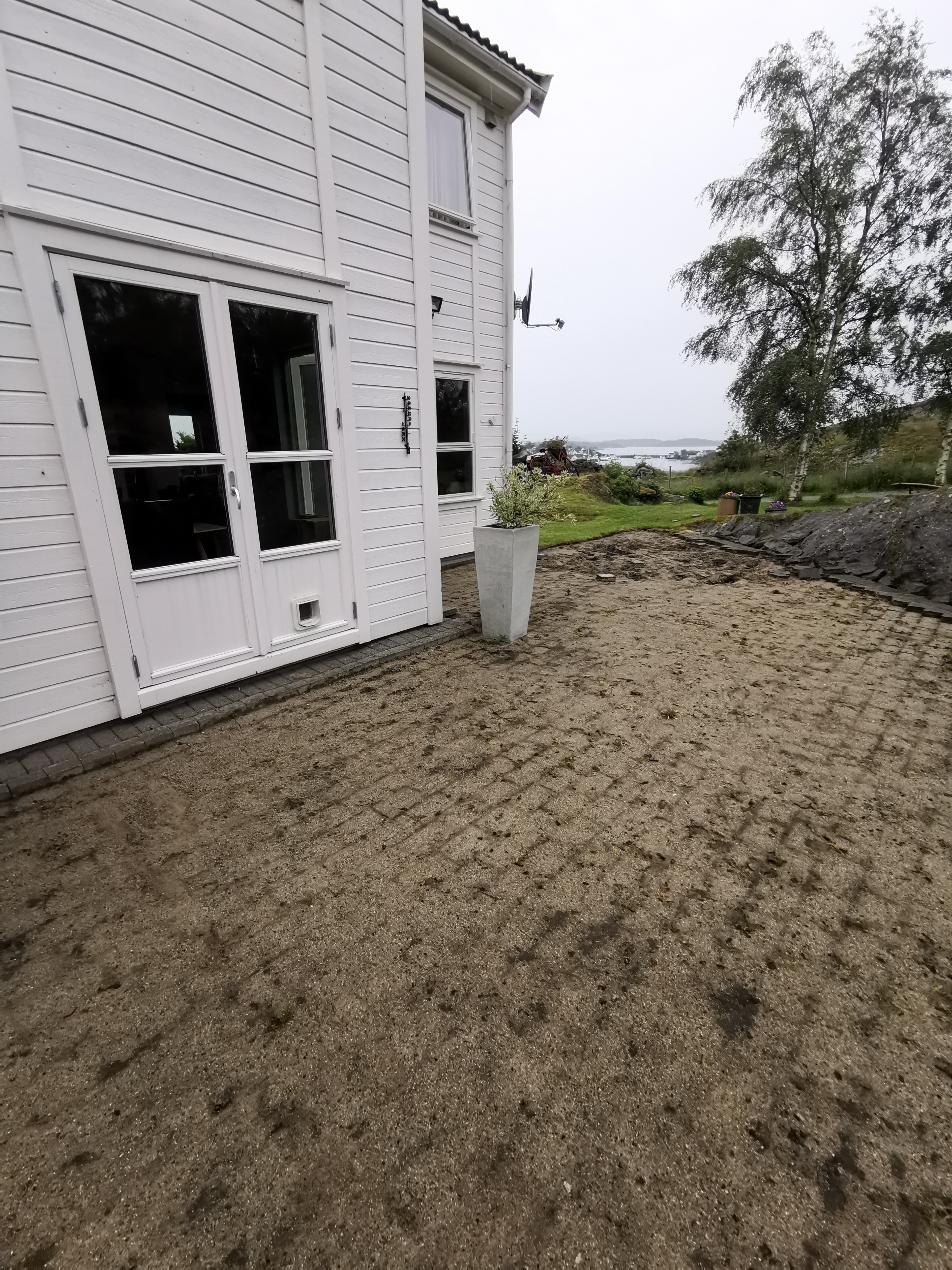 Utgravd område ved fasaden etter fjerning av eksisterende belegg