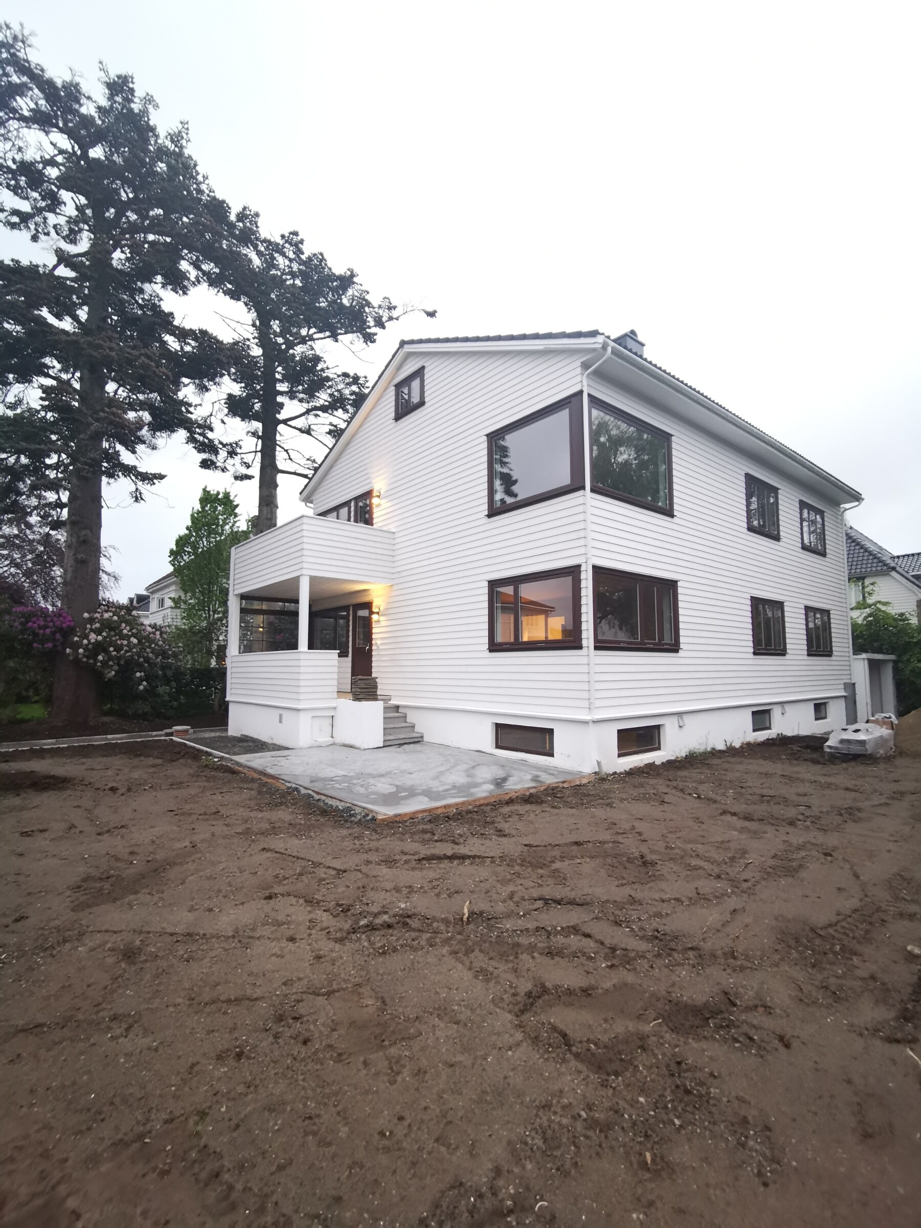 Huset med ny betongkant og uferdig terreng rundt